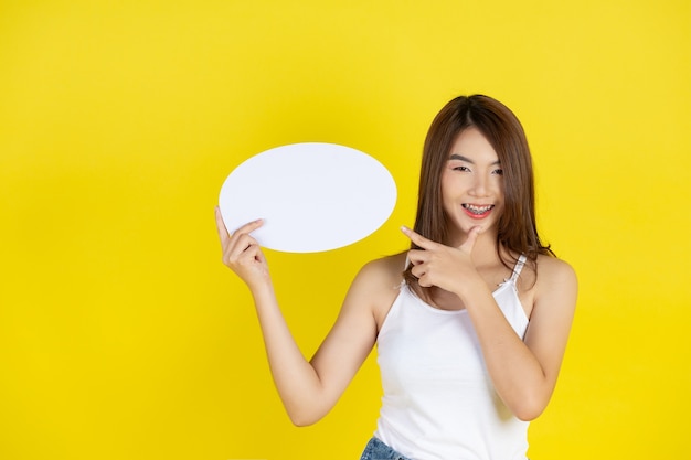Beautiful asian woman holding and looking up to speech bubble with empty space