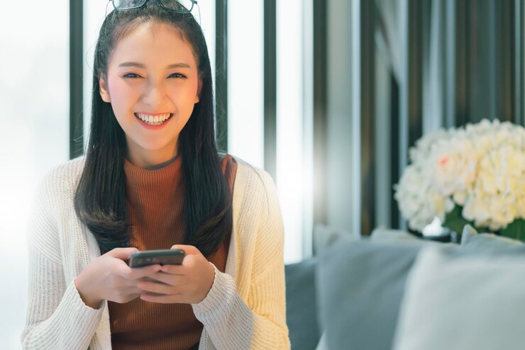 無料Photo 幸せな笑顔と前向きな思考を持つ美しいアジアの女性の長い黒髪の肖像画の白いセーター