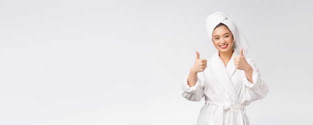 Free photo beautiful asian woman perfect skin showing thumbs up isolated on white background