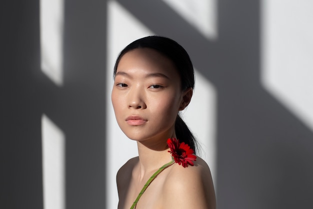 Beautiful asian woman posing holding rose with perfect skin