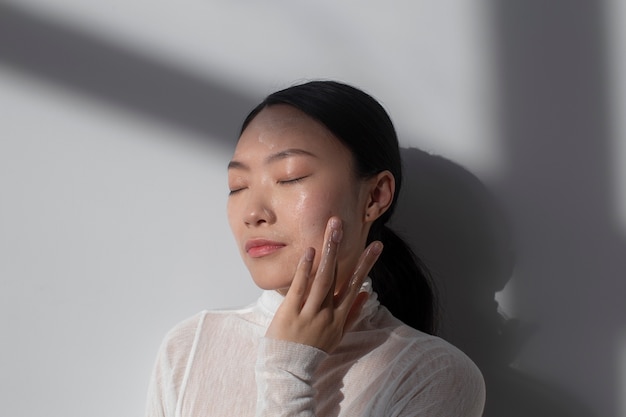 Beautiful asian woman posing with facial cream