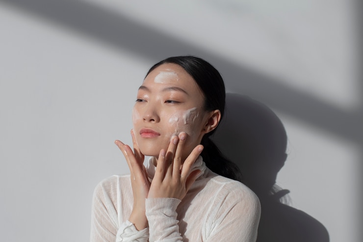無料Photo フェイシャルクリームでポーズをとる美しいアジアの女性