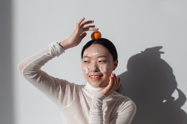 얼굴 크림과 함께 포즈를 취하는 아름다운 아시아 여성