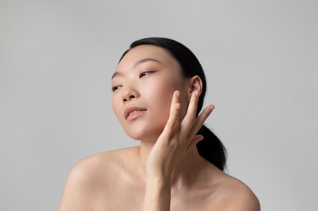 무료 사진 완벽한 피부로 포즈를 취하는 아름다운 아시아 여성