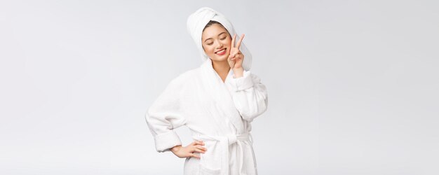 Beautiful asian woman showing peace sign or two finger with happy feeling Isolated over white background