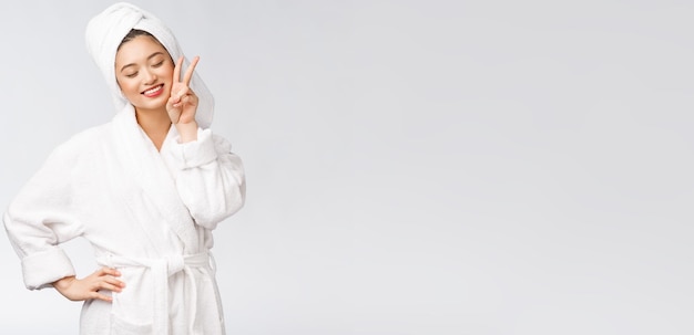 Free photo beautiful asian woman showing peace sign or two finger with happy feeling isolated over white background