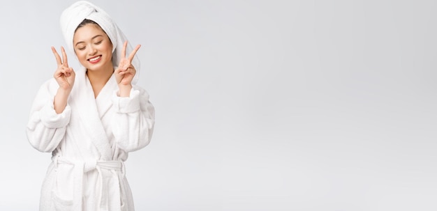 Beautiful asian woman showing peace sign or two finger with happy feeling Isolated over white background