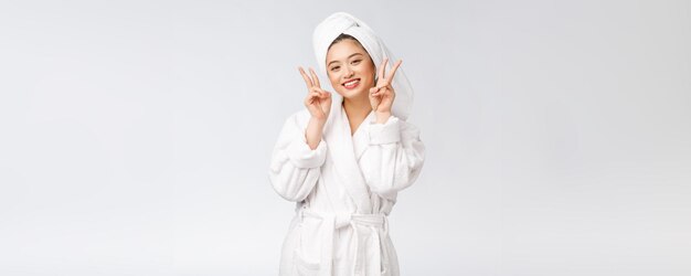 흰색 배경 위에 격리된 행복한 느낌을 가진 평화 기호 또는 두 손가락을 보여주는 아름다운 아시아 여성