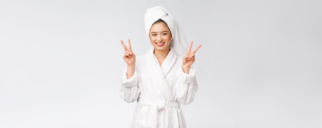 Beautiful asian woman showing peace sign or two finger with happy feeling Isolated over white background