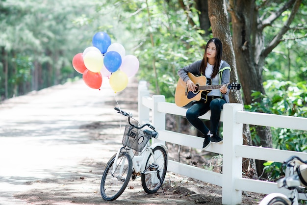 Beautiful Asian woman  smiling with Acoustic guitar