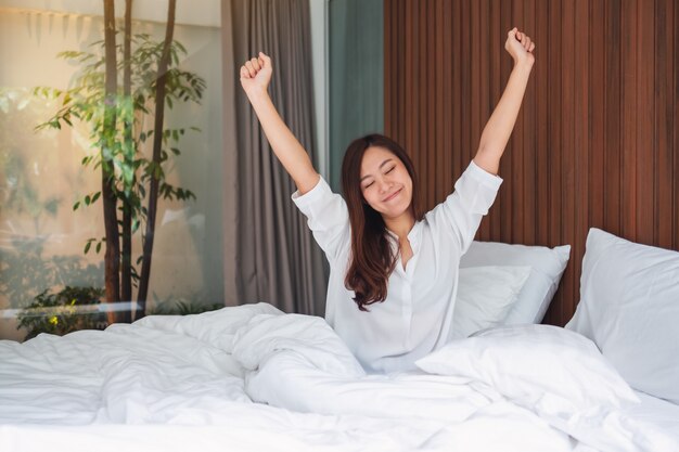 Premium Photo | A beautiful asian woman do stretching after waking up in  the morning on a white cozy bed at home