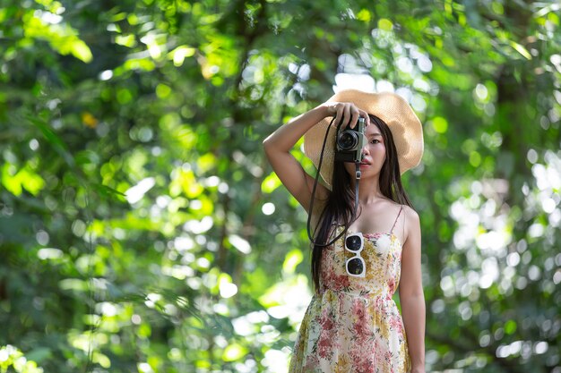красивая азиатская женщина принимая фото в парке