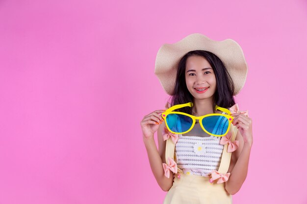 A beautiful Asian woman wearing a hat and large glasses with a pink .