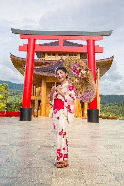 Красивая азиатская женщина нося японское кимоно, традиционную концепцию платья.