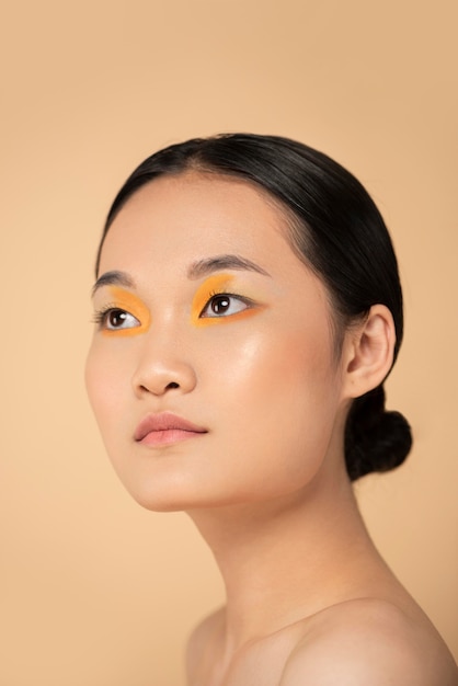 Free photo beautiful asian woman wearing orange eyeshadow