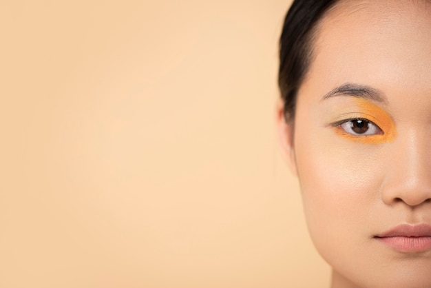 Free photo beautiful asian woman wearing orange eyeshadow