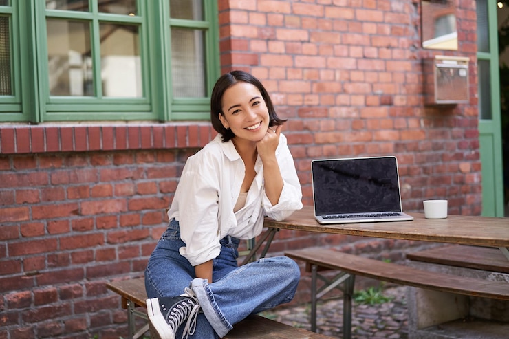 Free Photo beautiful asian woman with laptop sitting and working in cafe laughing and smiling drinking coffee