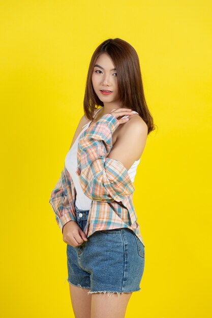 Beautiful asian woman on yellow wall
