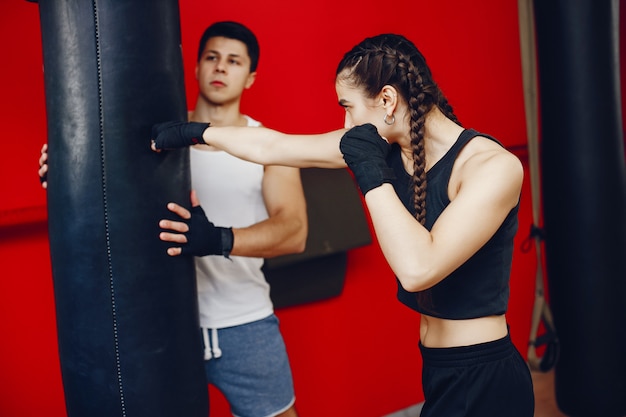 A beautiful and athletic sportswear girl training in the gym with her boyfriend