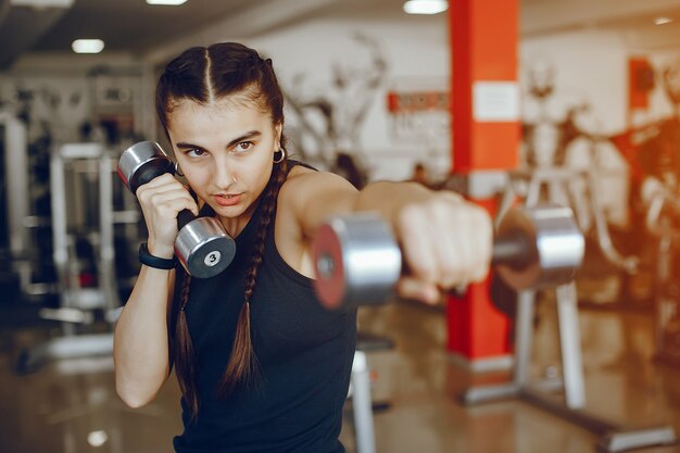 A beautiful and athletic sportswear girl training in the gym