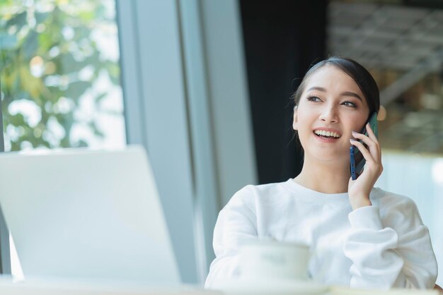 beautiful attractive asian female freshness smile cheerful morning working with laptop coffee work from home with happiness enjoy garden view asian young woman with window light garden background