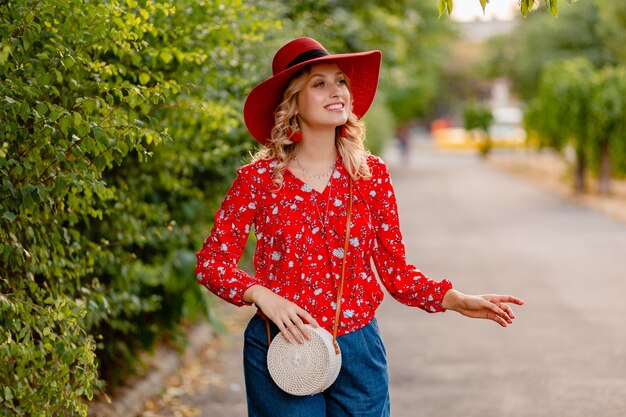 Красивая привлекательная стильная блондинка улыбается женщина в соломенной красной шляпе и блузке летней моды