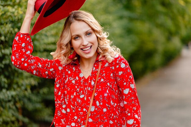 Beautiful attractive stylish blond smiling woman in straw red hat and blouse summer fashion outfit