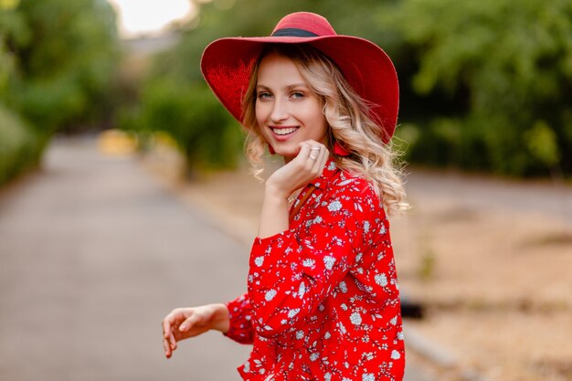 Beautiful attractive stylish blond smiling woman in straw red hat and blouse summer fashion outfit