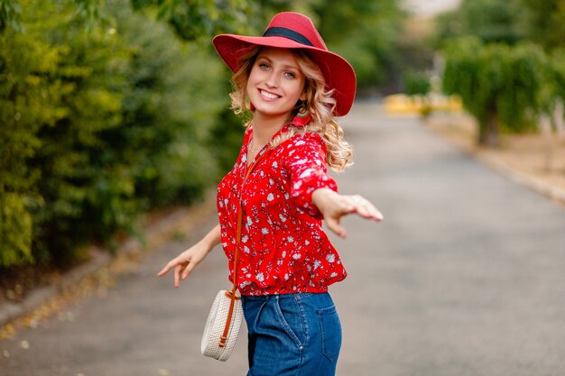 Beautiful attractive stylish blond smiling woman in straw red hat and blouse summer fashion outfit