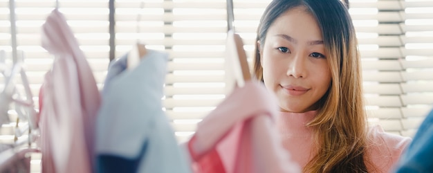 家や店のクローゼットの中で彼女のファッション衣装の服を選ぶ美しい魅力的な若い女性。