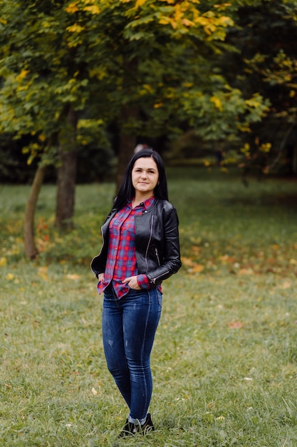 Beautiful Autumn Girl Portrait. Young Woman Posing Over Yellow Leaves In The Autumn Park. Outdoor