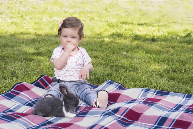 Free photo beautiful baby playing with bunny on blanket