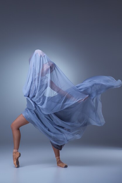 파란색 배경에 긴 파란색 드레스를 입고 아름다운 발레리나 춤