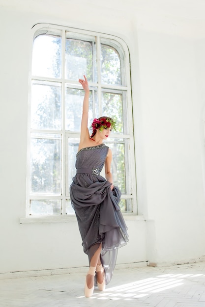 The beautiful ballerina dancing in long gray dress