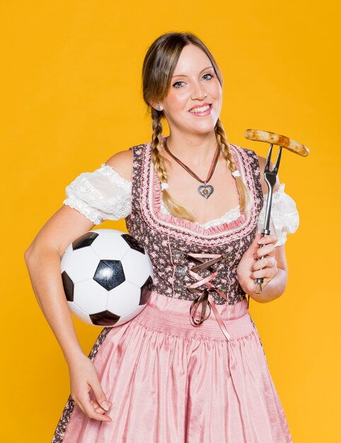 Beautiful bavarian woman with football 