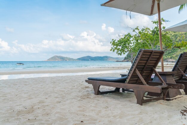 Beautiful beach chairs with umbrella on tropical white sand beac