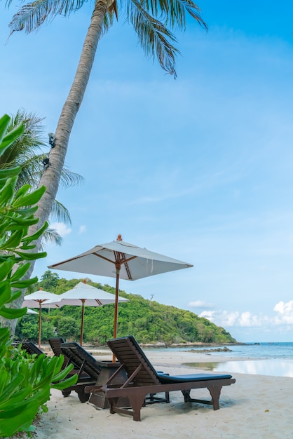 Beautiful beach chairs with umbrella on tropical white sand beac