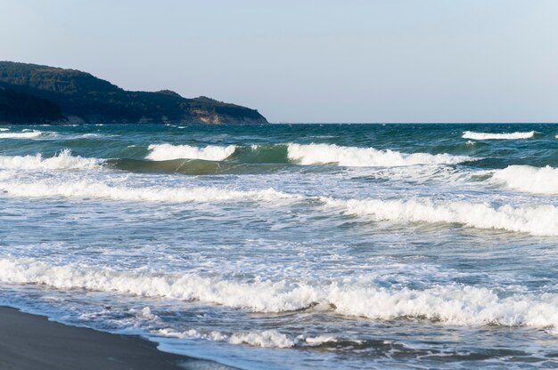 Красивый вид на пляж с волнами, разбивающимися о пляж