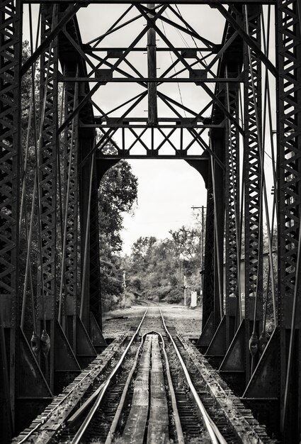 Beautiful black and white shot of a railroad on a metal bridge