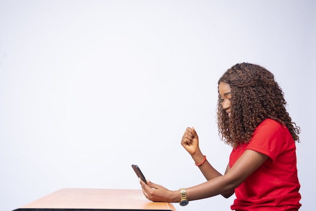 Beautiful black woman excitedly looking at her phone