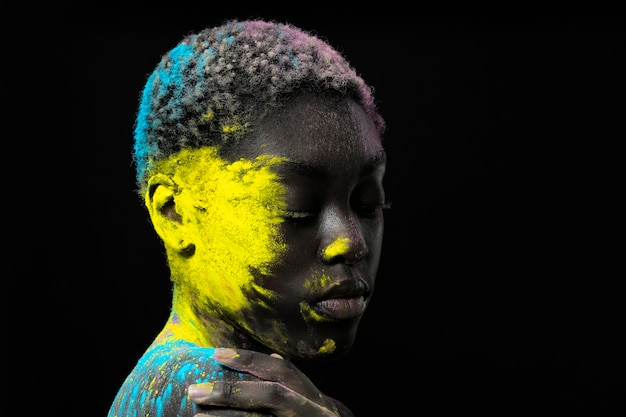 Beautiful black woman posing with colorful powder