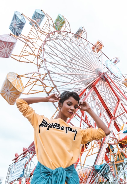 Beautiful black woman wearing yellow sweatshirt in an amusement park 