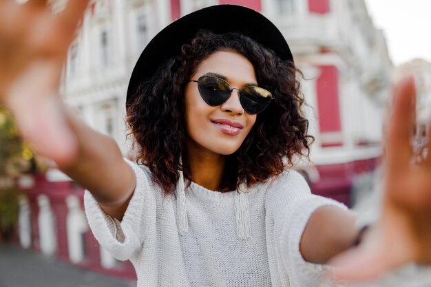 Beautiful black woman with stylish Afro hairs making self portrait.