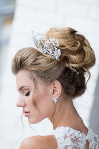 Beautiful blonde bride with high hair-do and precious silver wreath on her hair