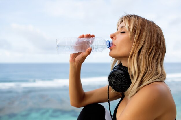 美しい金髪の飲み物の水