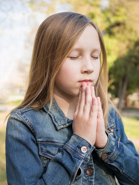 Beautiful blonde girl praying