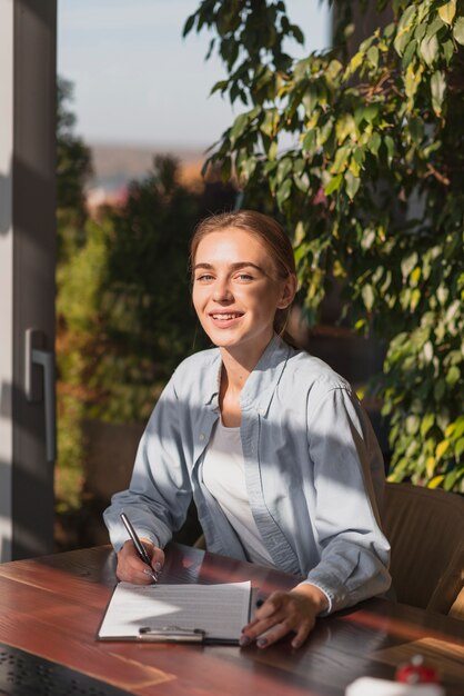 Beautiful blonde girl writing on a clipboard