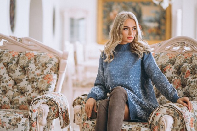 Красивая блондинка сидит на диване