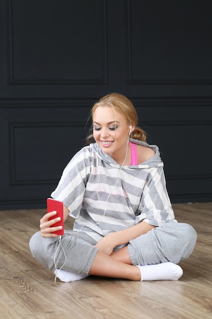 Beautiful blonde sitting on wooden floor