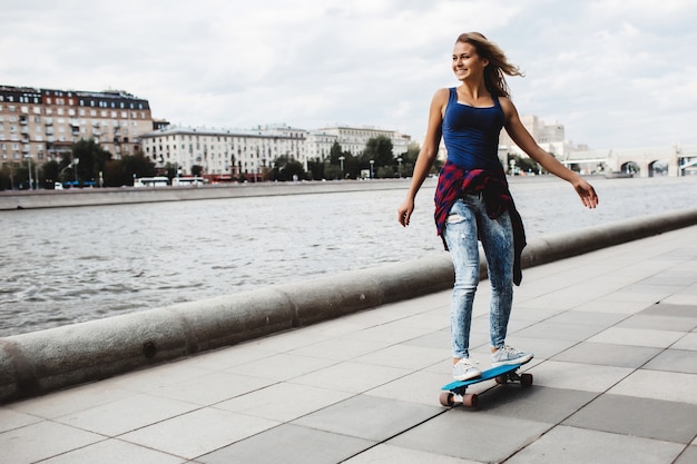 Бесплатное фото Красивая блондинка скейтборд на набережной